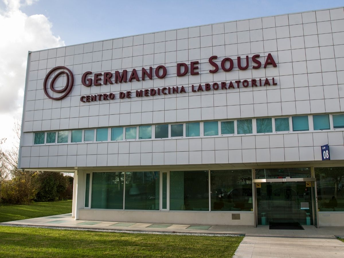 Edifício moderno e branco do GERMANO DE SOUSA CENTRO DE MEDICINA LABORATORIAL. O logótipo e o nome estão em destaque na fachada.